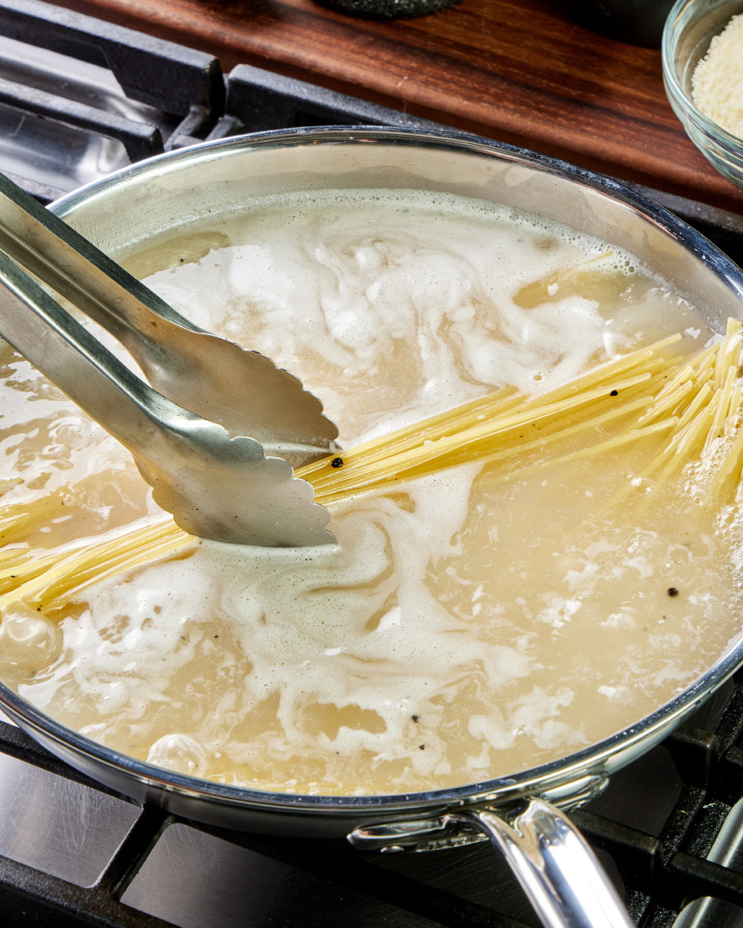 3. Bring to a boil over medium-high and cook, uncovered and frequently moving the pasta about with tongs but keeping it submerged.