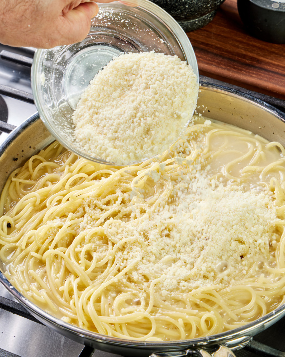 5. With the pan still on medium-high, add about half of the remaining cheese mixture. Toss this first addition of cheese with the noodles until fully melted.