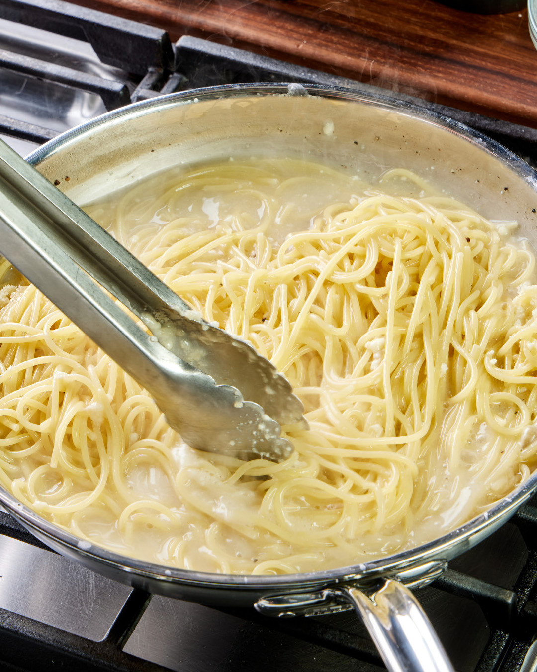 7. While still on medium-high, continue tossing the spaghetti until al dente and lightly sauced, with about ¼ cup of creamy sauce pooled in the skillet.