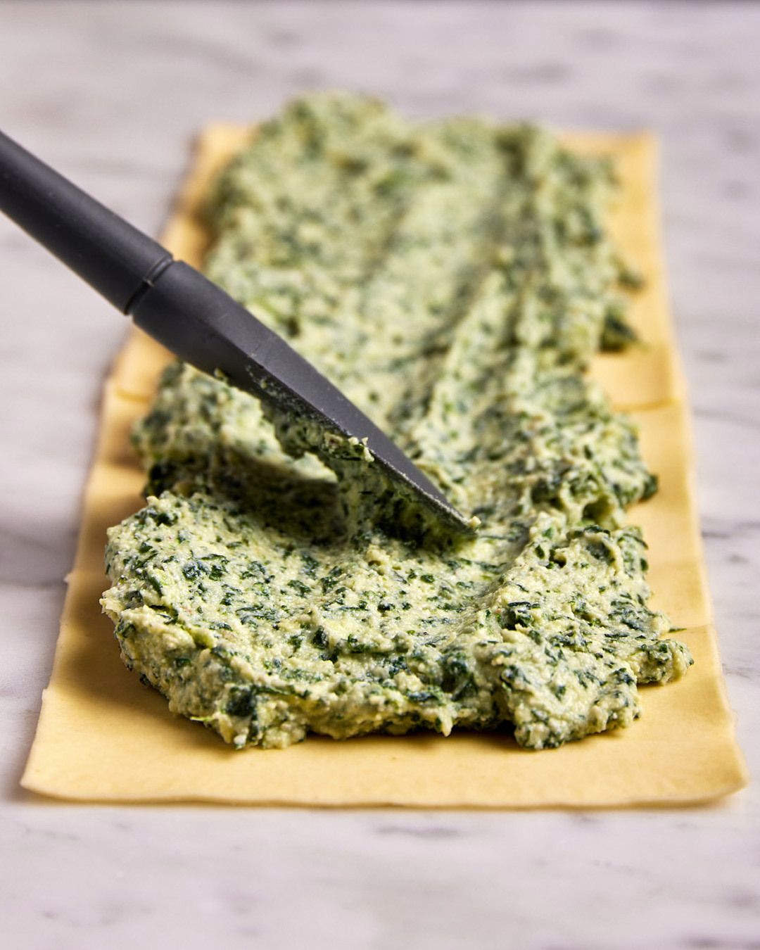 2. Place 1 cup of the ricotta-spinach filling in the center of the lasagna sheet and spread it evenly, leaving about a ½-inch border around all edges.