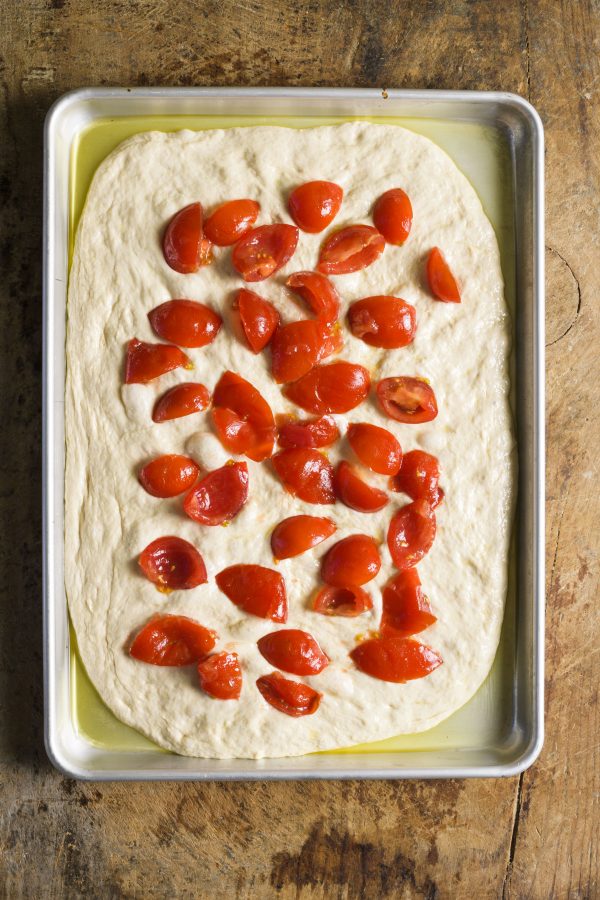 3. Top the dough evenly with tomatoes, leaving a narrow border, then let rest for 30 minutes.