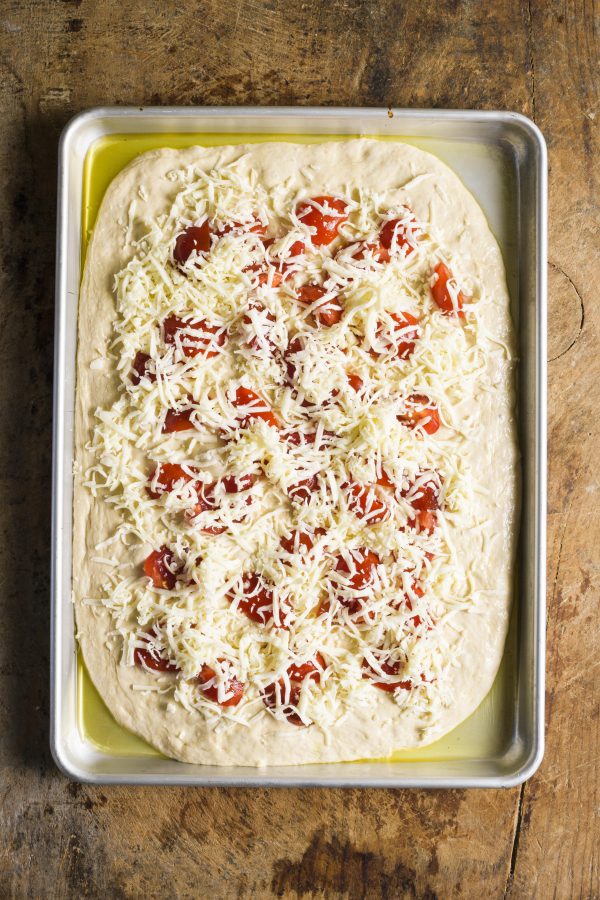4. Add any additional toppings to the pizza, then sprinkle the cheese evenly over the top.
