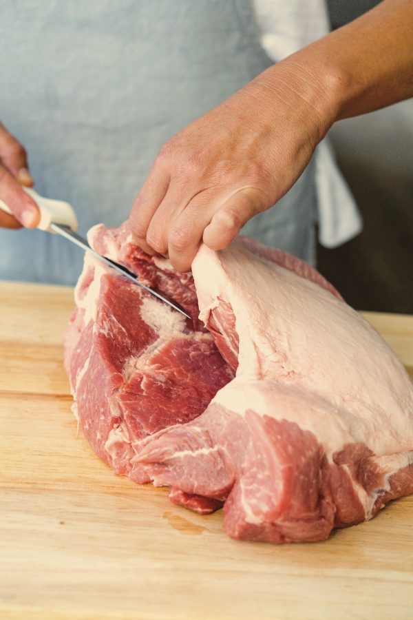 ​1. Once you remove any netting from the boneless pork butt, located the incision made by the butcher to remove the bone from the meat. Begin to cut the pork butt here.